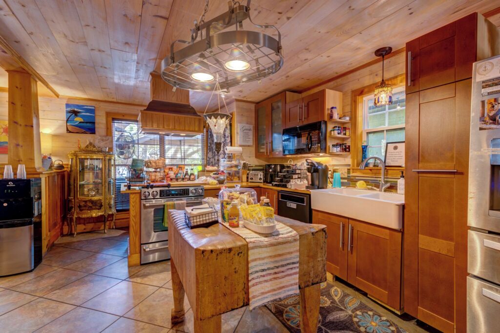 Cottage kitchen with an island and pendant lights at Beachside Boutique Inn