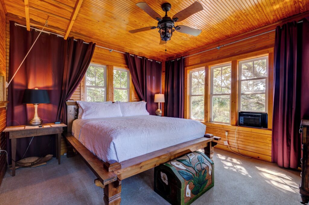 Wood-paneled guest room with a queen bed at Beachside Boutique Inn