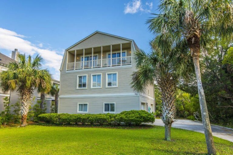 Folly Beach vacation home with a lawn and palm trees