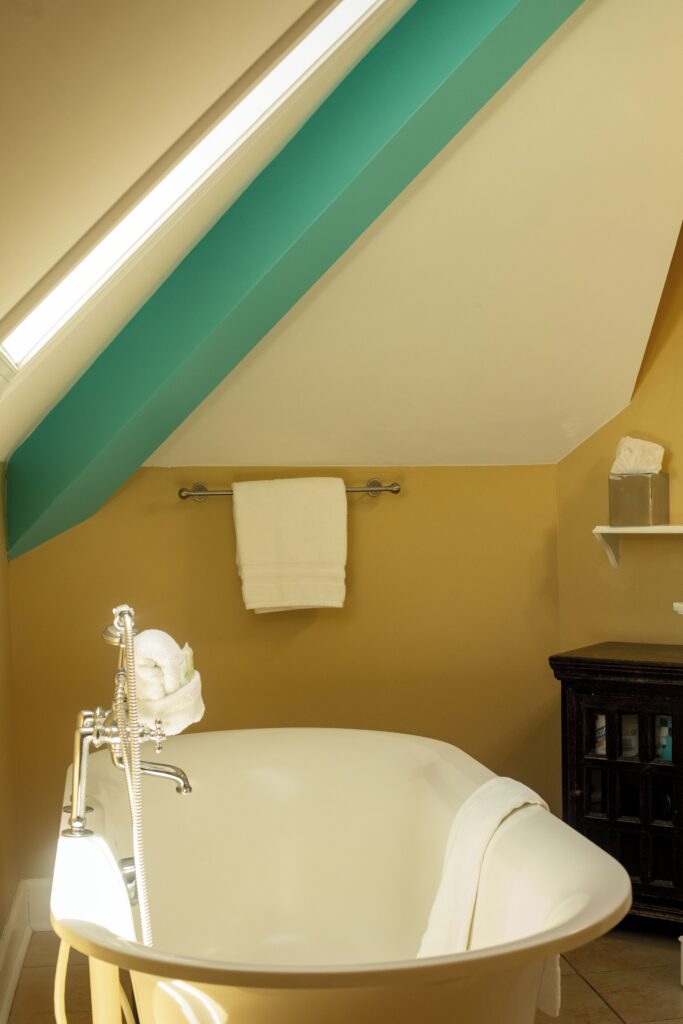 Clawfoot soaking tub under a sloped ceiling at Water’s Edge Inn